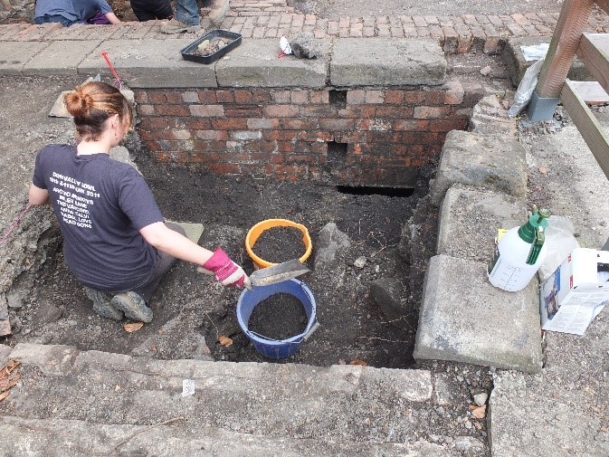 alt="volunteer trench 1 uncovering stoking hole"