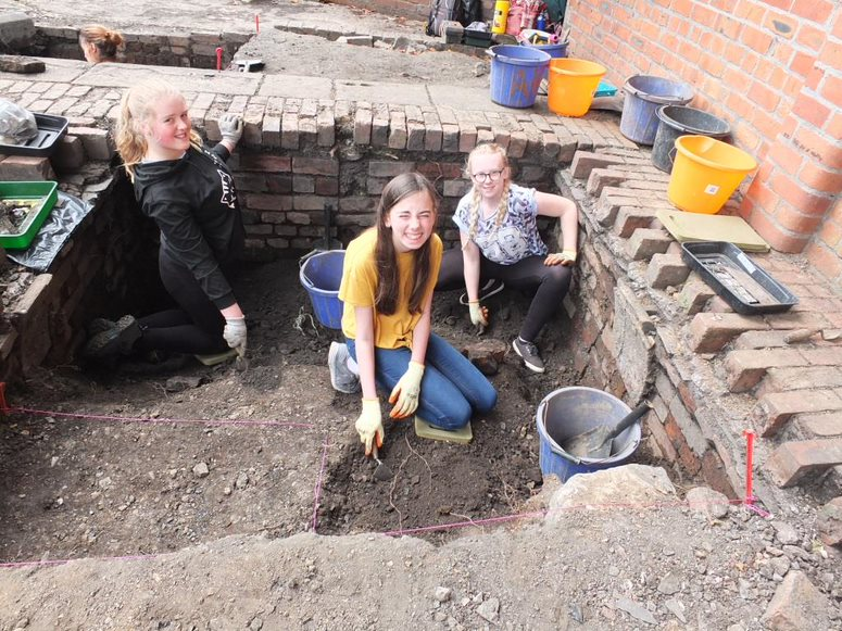 alt="young people digging"