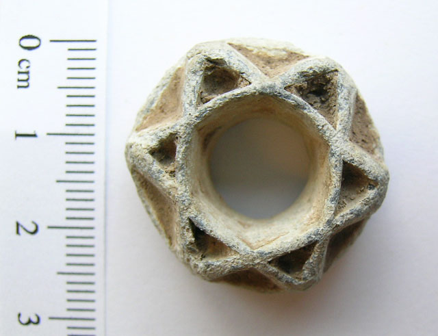 alt="ornate white six-sided object 2.5cm across with star of david decoration and round hole through the middle"