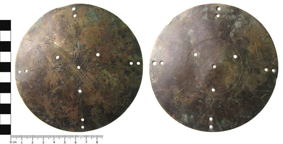 Photographs of the back and front of a compass - a metal disk with holes punched in it - from the Portable Antiquity Scheme database