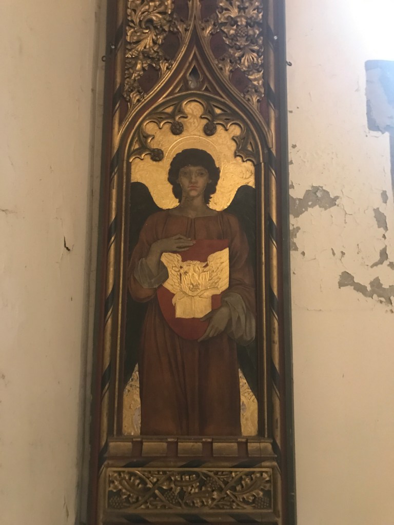 A panel on a wallk in the church, There is a person in the centre of the frame holding a red object that has a bright gold centre