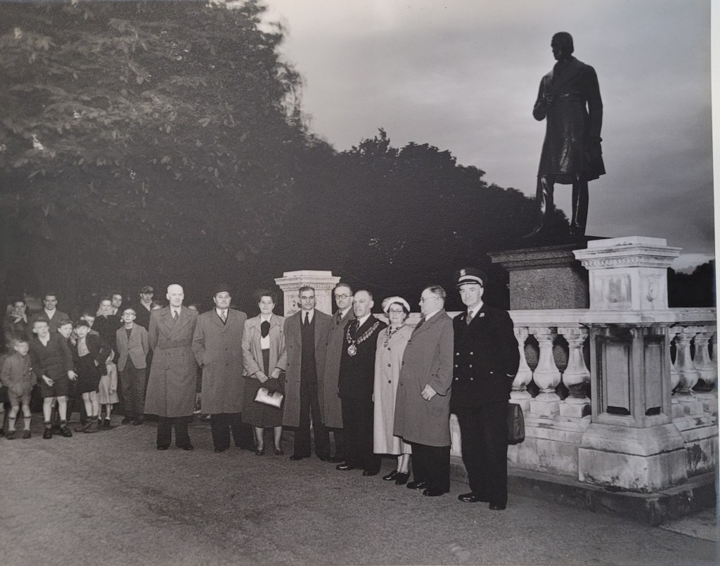 A group of people standing in Locke Park at dusk