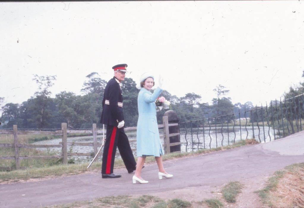 The Queen and Duke walk across  bridge at Cannon Hall