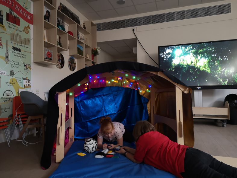 A facilitator in a small tent in the learning lab 