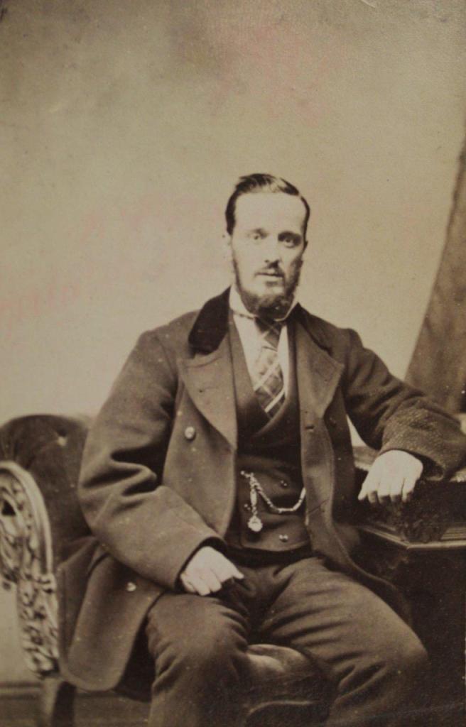 A man dressed in a suit with a pocket watch attached to his waistcoat
