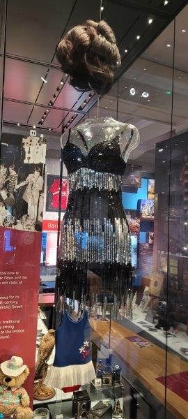 A black and silver dress and wig which is on display in the museum 