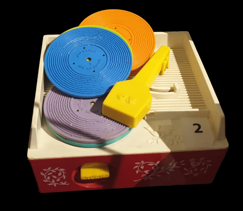 A red fisher price record player with blue and purple plastic records