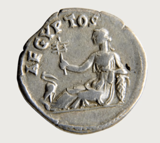 A silver coin with the word Aegypros on the front