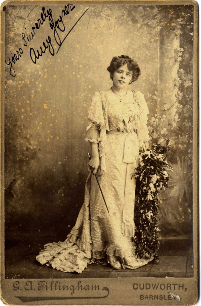 A potrait of Amy Joyner who is wearing a white dress.