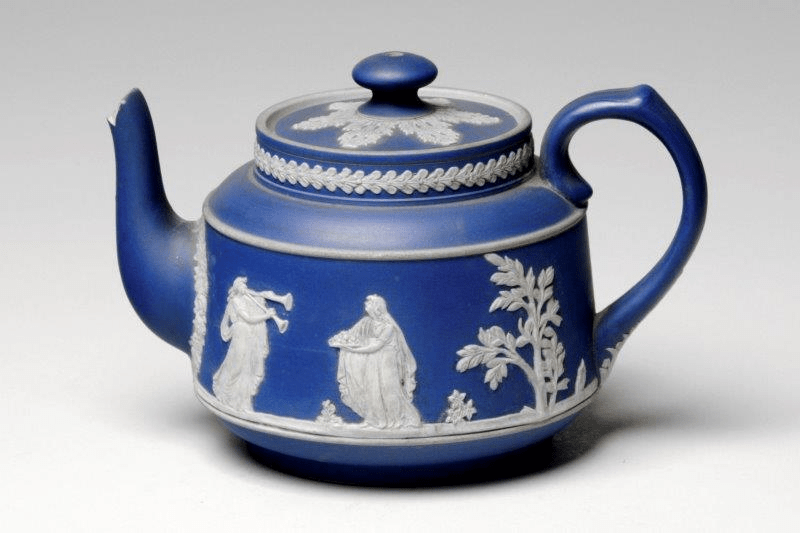 Ceramic teapot and lid which are part of a partial tea set together with sugar bowl and milk jug. They are all made in the style of jasperware developed by Wedgwood in the 18th century