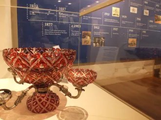 a red glass epergne in a display case