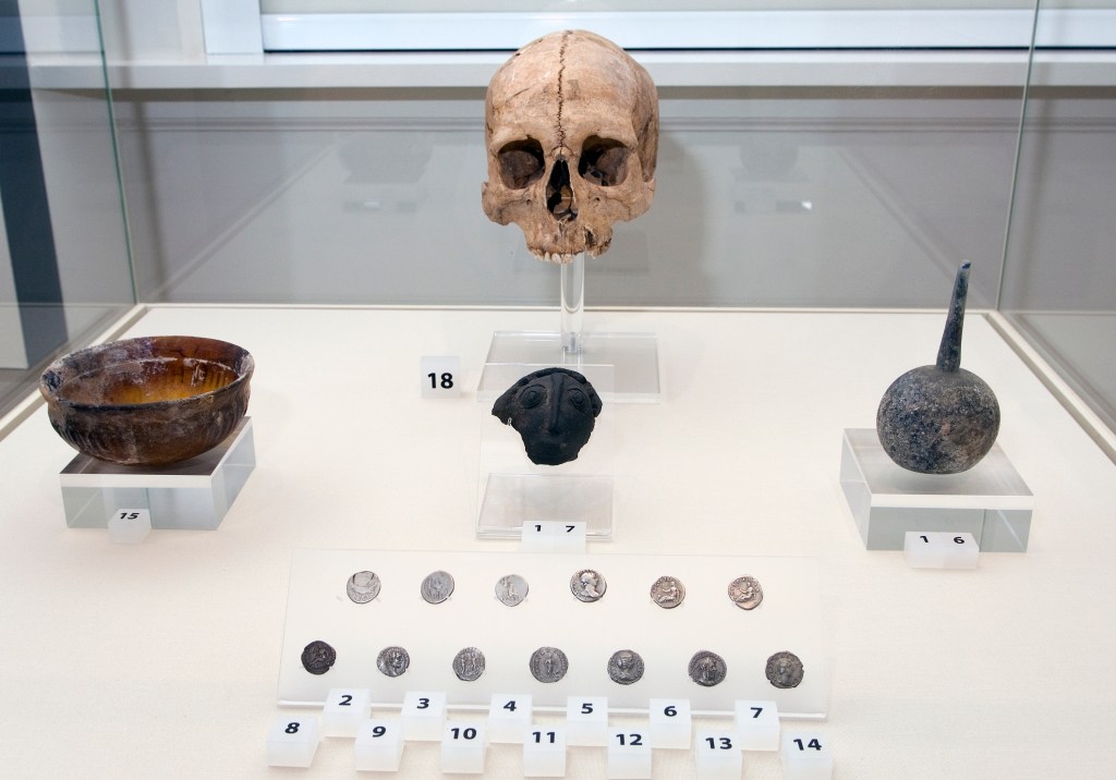 objects on display in the exhibition including a skull and coins