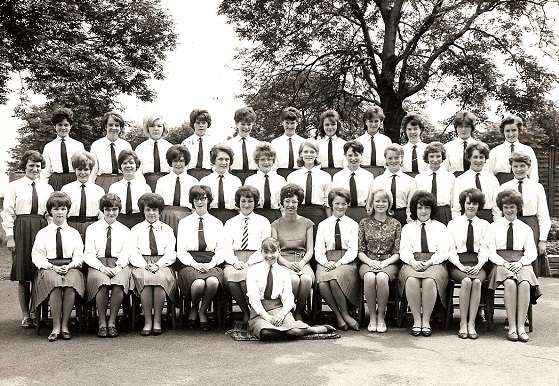 A school group photograph everyone is in uniform and the teachers are on the front row