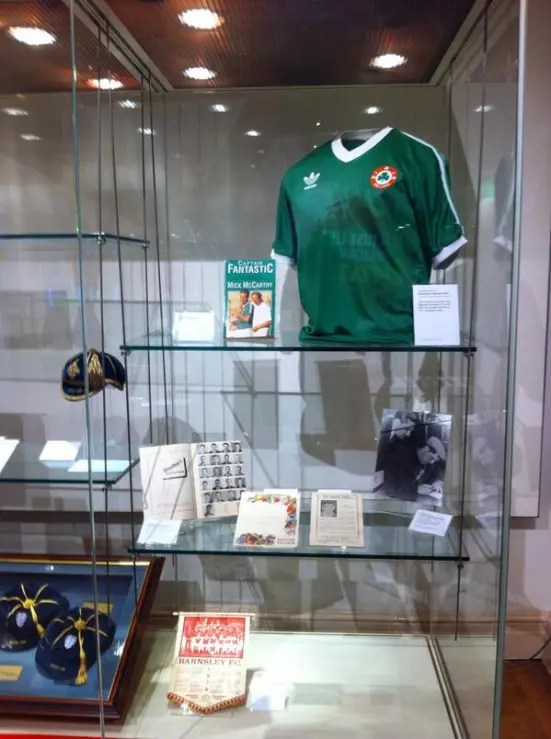 A case in the exhibition which includes a green t shirt