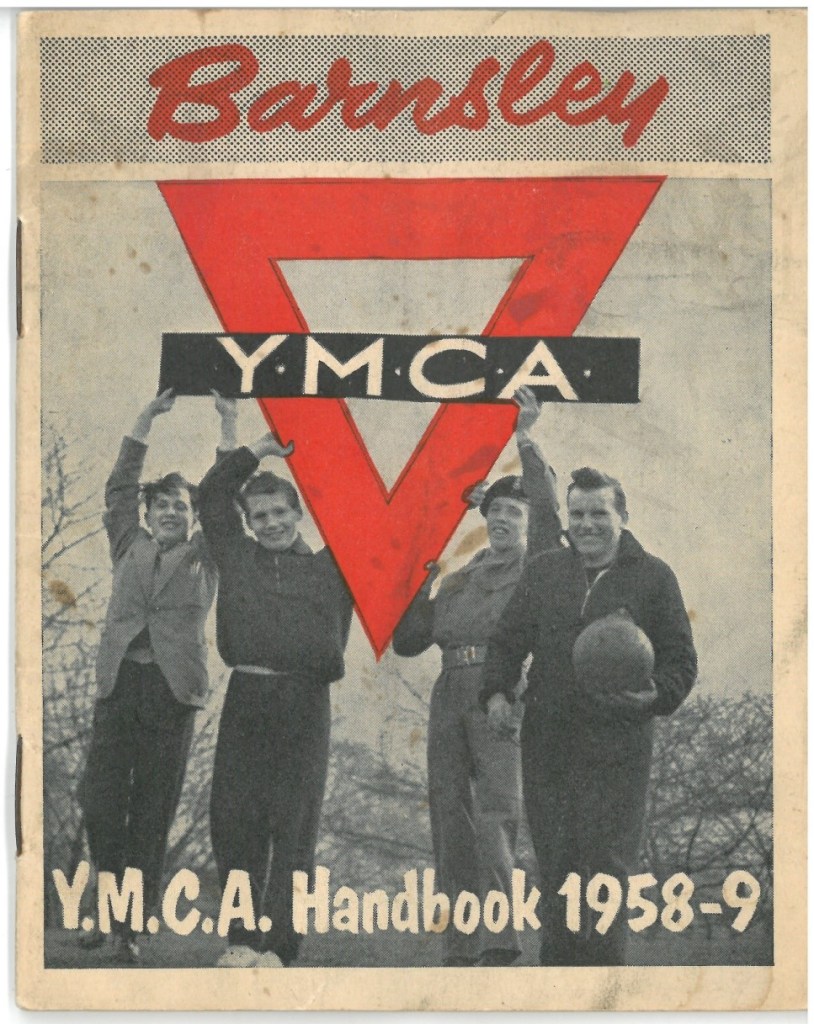 Cover of the Barnsley YMCA handbook 1958-9. There is a black and white photograph of four young men, one is holding a football and the other three appear to be holding the YMCA logo, which is a red triangle with a black rectangle across the middle which has YMCA on it in white letters.