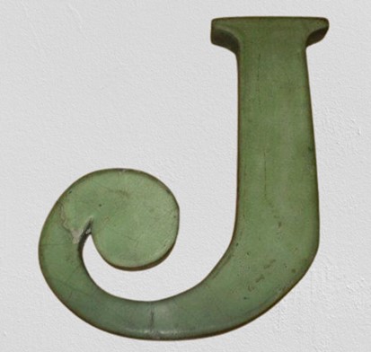 Green tile in the shape of the letter J
