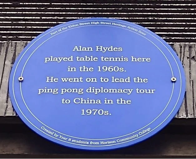 A blue plaque which reads, Alan Hydes played table tennis here in the 1960s. He went on to lead the ping pong diplomacy tour to China in the 1970s.