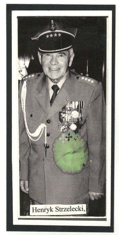 A black and white photo of an elderly man in a military uniform adorned with various medals. He is smiling and wearing a peaked cap. A portion of the image is marked with a green hue. There is a caption below the photo reading "Henryk Strzelecki".