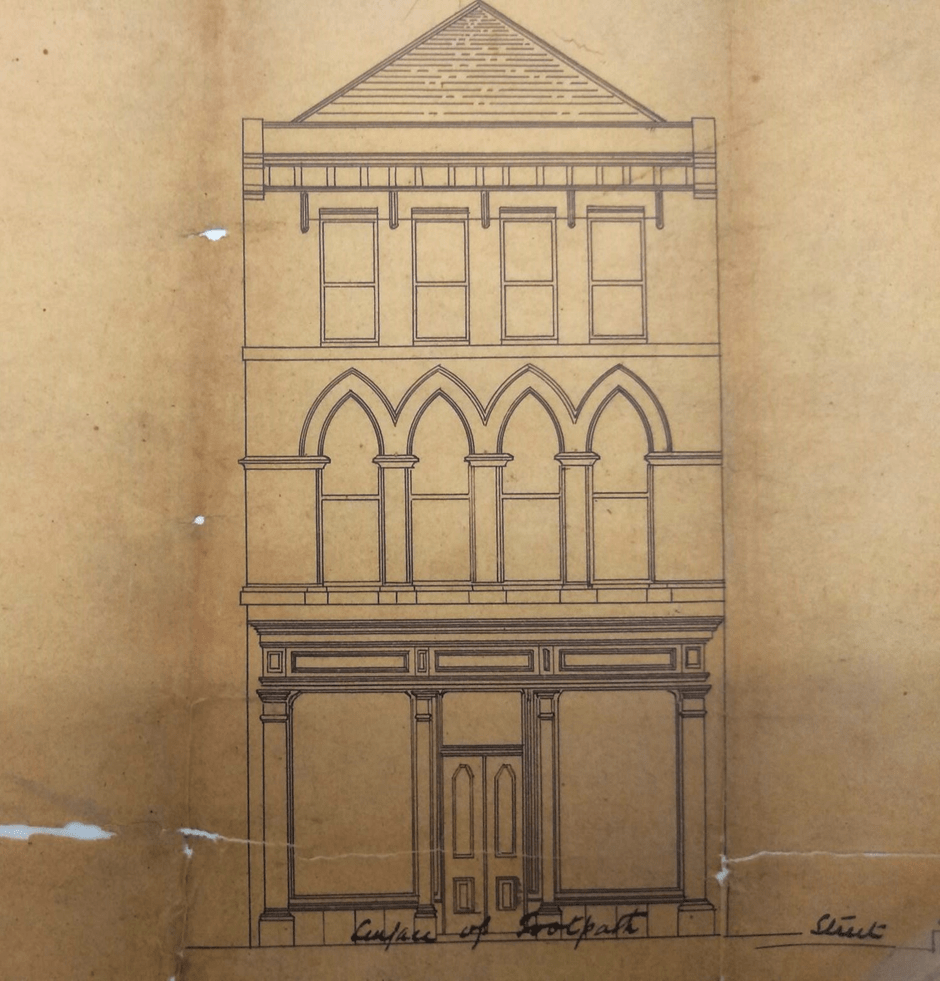A vintage architectural drawing shows the front elevation of a three-storey building with arched second-floor windows and a triangular pediment roof. The ground floor features a detailed doorway and decorative trim. The text "Surface of Footpath" is written below.