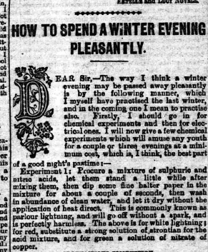 Six men are posing on a stack of wooden planks at a construction site. Four are shirtless, and two are wearing shirts. A row of houses and several smokestacks are visible in the background. The photo has an old, sepia tone.