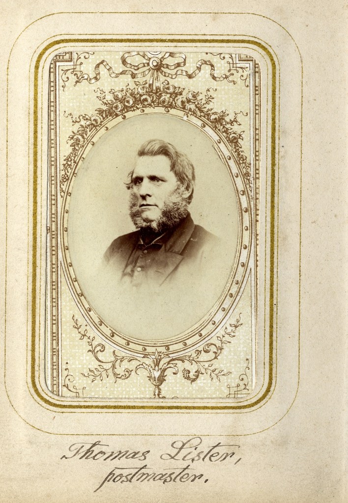 Sepia-toned portrait of a man from the 19th century with sideburns, wearing a dark coat. The photograph is in an ornate, oval frame on a cream card with decorative details. Handwritten text reads "Thomas Liston, postmaster.