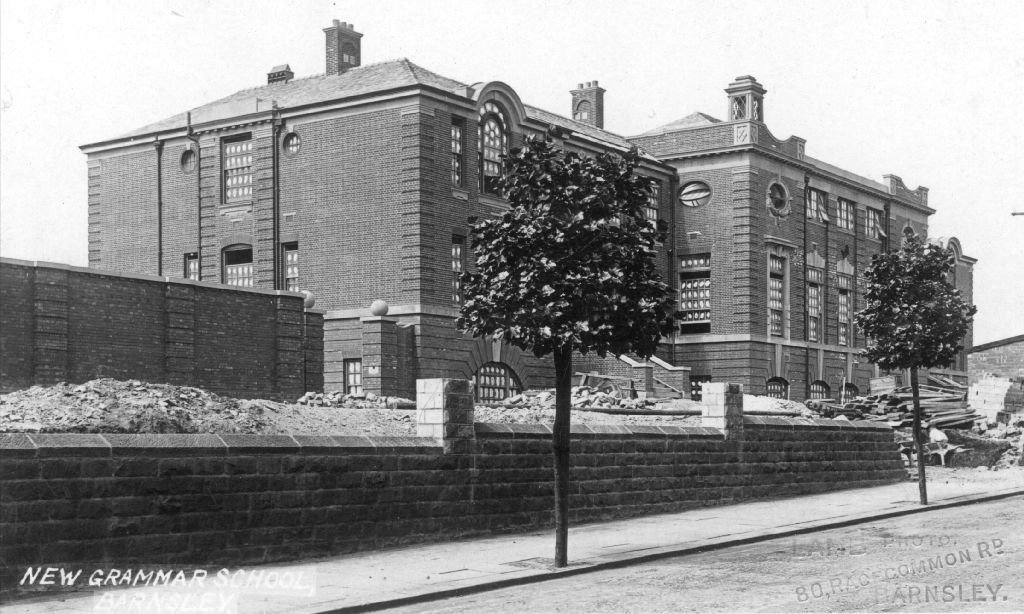 Historic black and white photograph of the New Grammar School in Barnsley, showcasing its architectural design and surrounding landscape.
