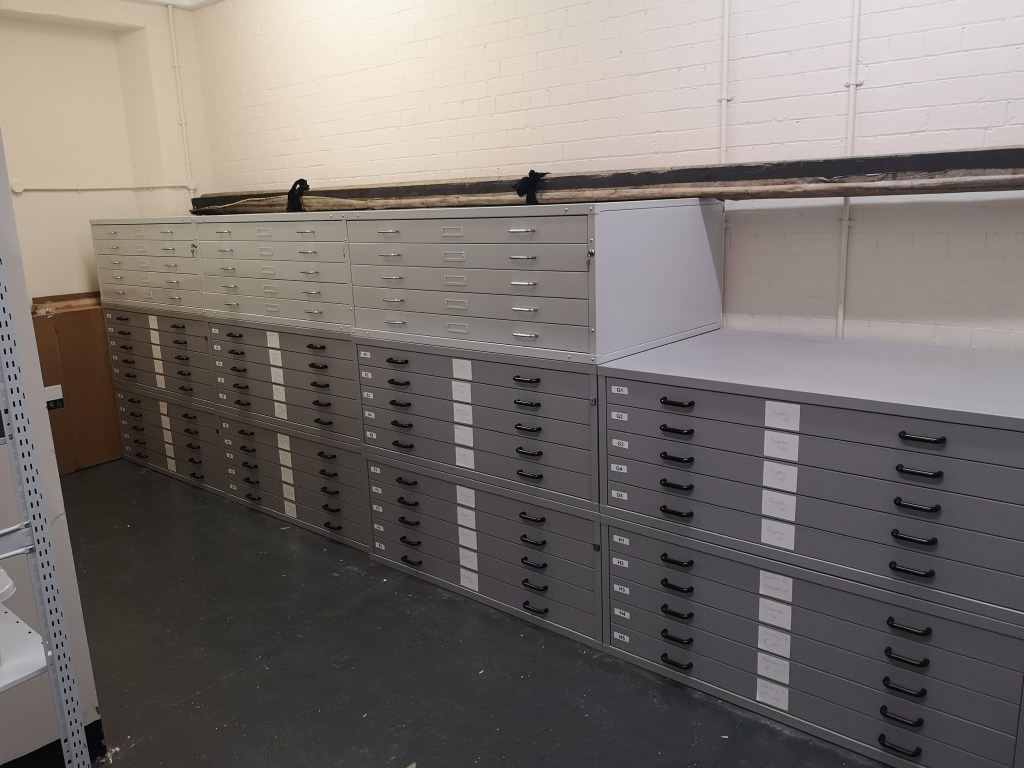 A storage area filled with grey archival drawers and cabinets, designed for preserving historical documents and collections.