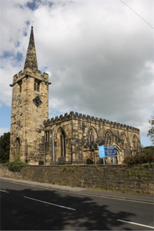 Exterior view of St. Mary's Church in Worsbrough Village, featuring a tall steeple and stone architecture, set against a cloudy sky.