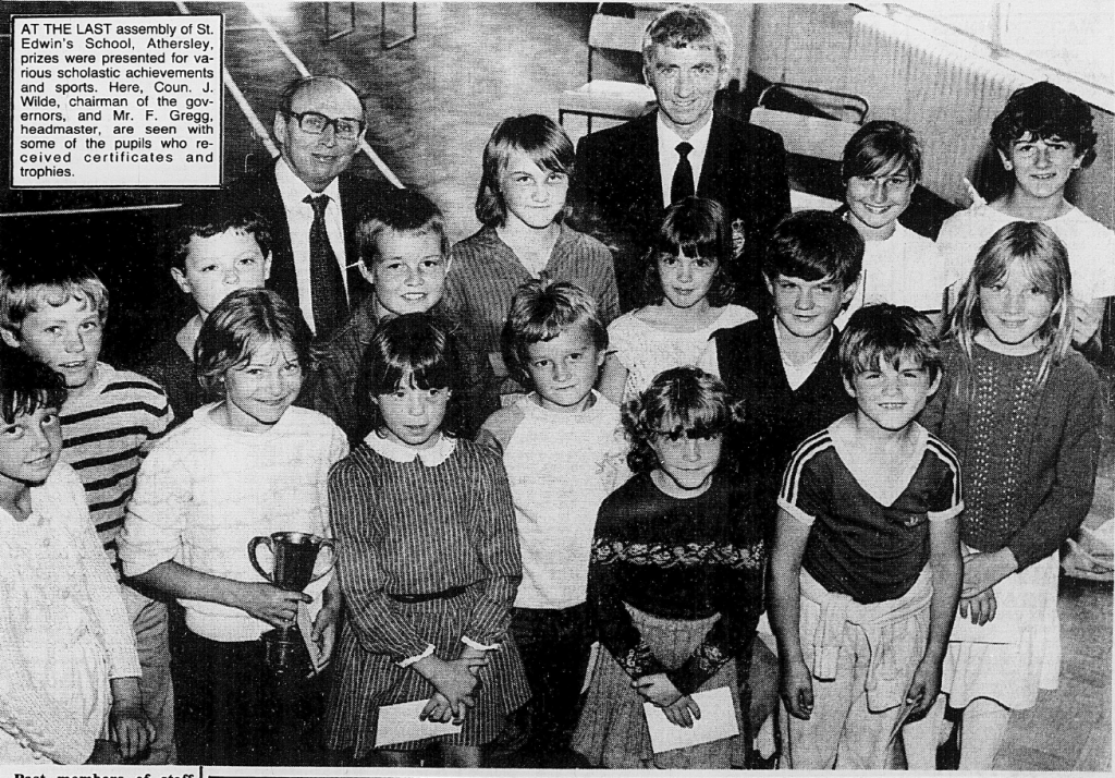 A group of children posing with a headmaster and a school governor during the last assembly at St. Edwin's School in Athersley, where prizes were awarded for various achievements.