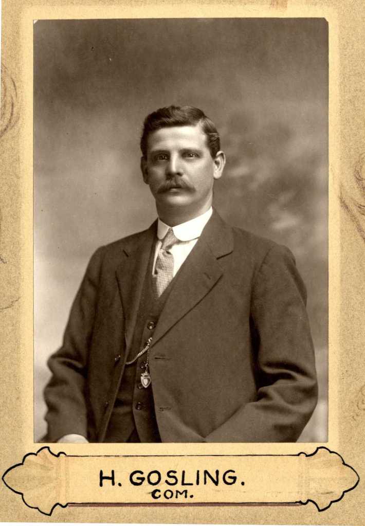 A sepia-toned portrait of H. Gosling, dressed in formal attire, featuring a mustache and a thoughtful expression. The image is framed with decorative edges and includes the name 'H. Gosling' and the detail 'Com.' at the bottom.