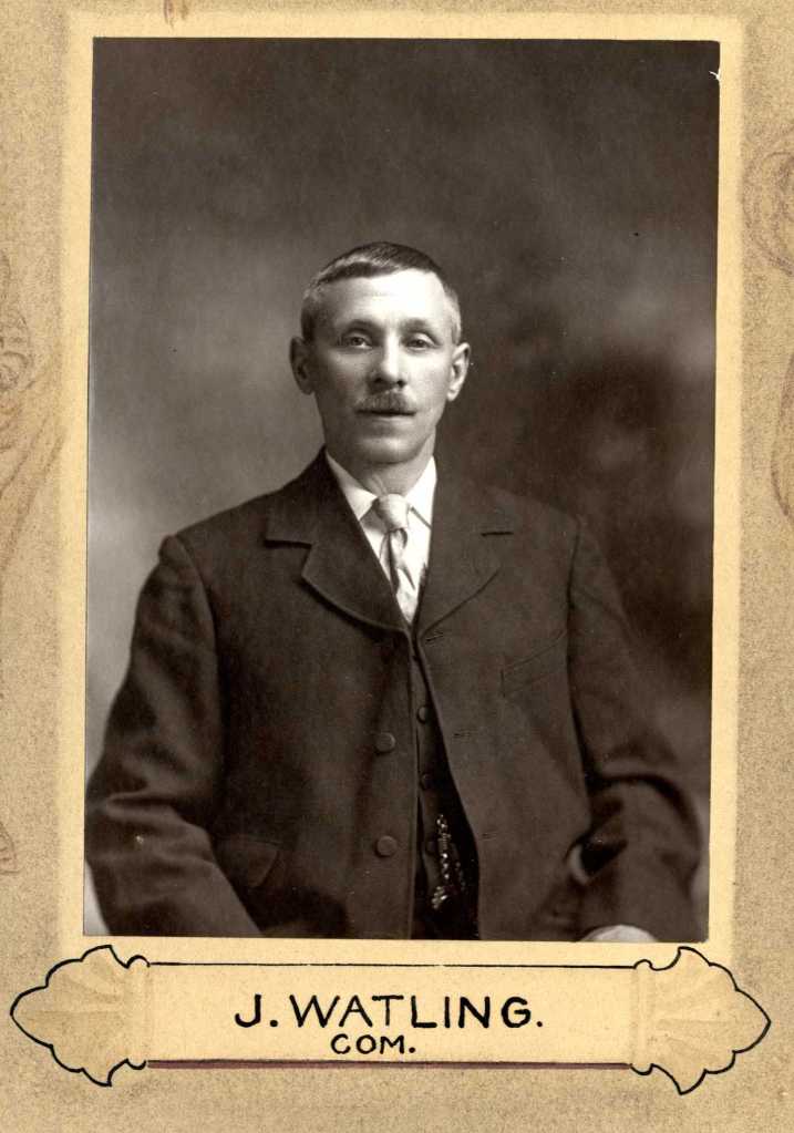 A black and white portrait of a man named J. Watling, with a mustache, dressed in formal attire, sitting against a plain backdrop.