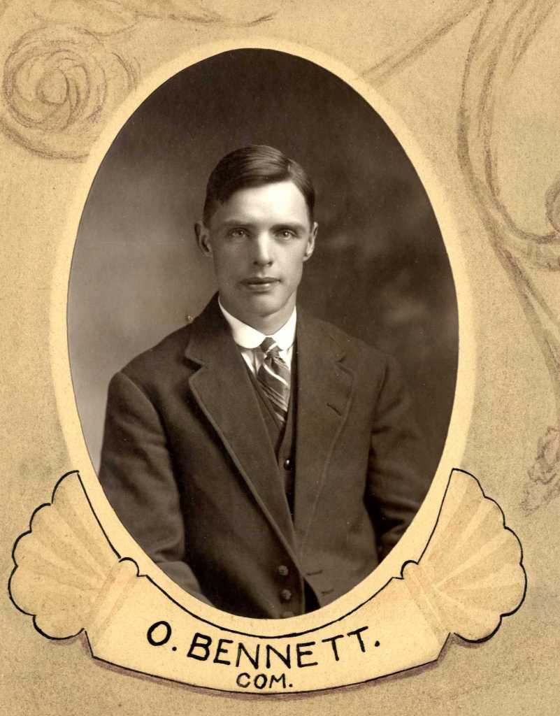 A sepia-toned portrait of a young man named O. Bennett, dressed in formal attire, featuring a suit and tie, with an oval border that includes ornate decorative elements.