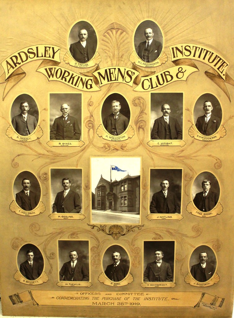 A framed display from March 1919 commemorating the purchase of the Ardsley Working Men's Club, featuring a central photograph of the club building and sixteen portraits of officers and committee members.