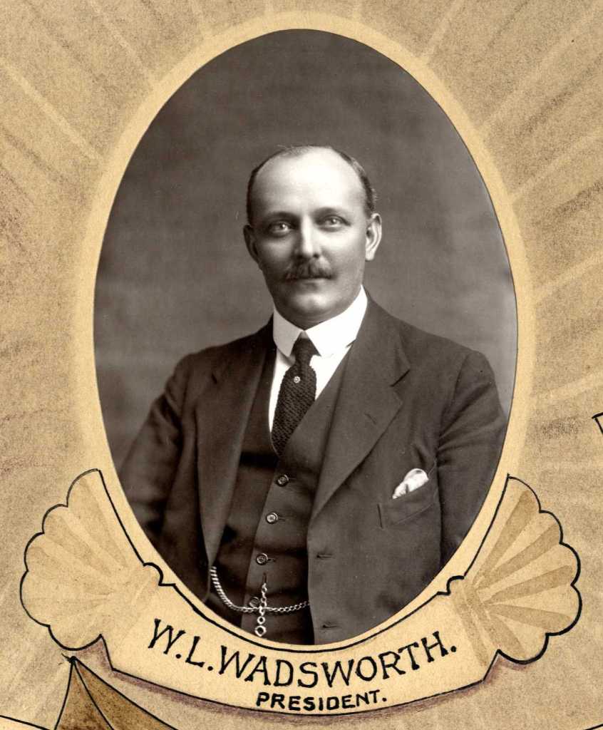 Black and white portrait of W.L. Wadsworth, who is identified as the President. He is dressed in a suit and tie with a pocket square, and has a mustache.