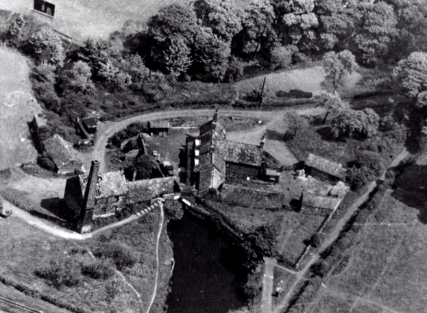 Aerial view of Worsbrough Mill complex, showcasing the historic buildings surrounded by lush greenery and a winding path.
