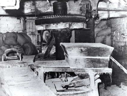 Interior view of Worsbrough Mill showcasing old milling machinery and flour bags.