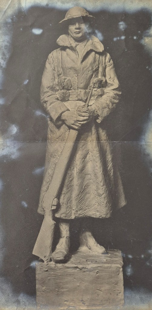 A historical image of a soldier statue that depicts a World War I soldier, dressed in a trench coat and helmet, standing with a rifle at his side, commemorating those who served in the war.